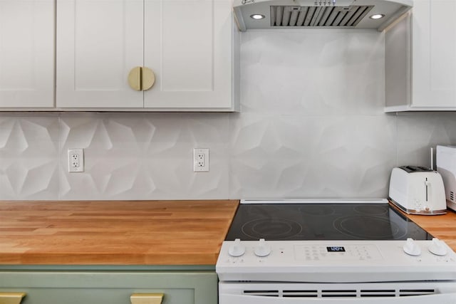 kitchen featuring butcher block countertops, white range with electric stovetop, ventilation hood, green cabinetry, and white cabinets