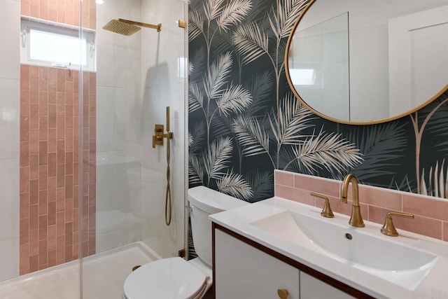 bathroom with tile walls, tiled shower, tasteful backsplash, vanity, and toilet