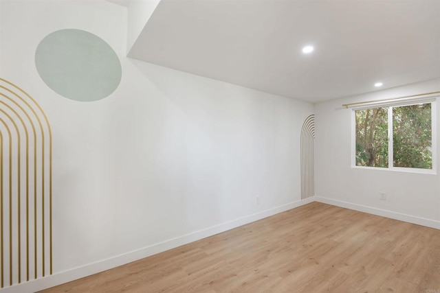 spare room with recessed lighting, light wood-style flooring, and baseboards