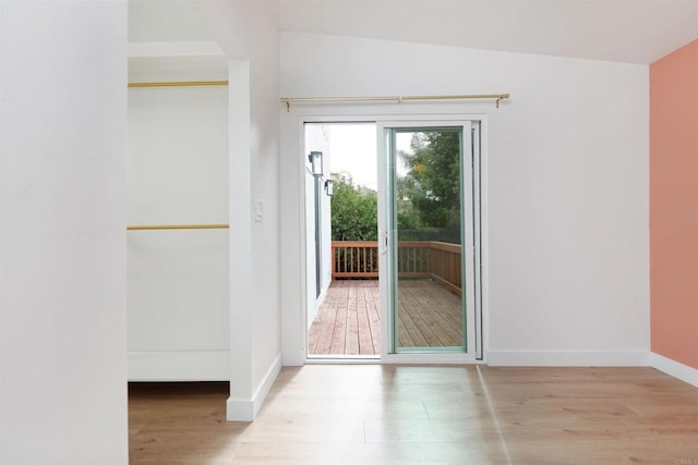 doorway to outside featuring baseboards and wood finished floors