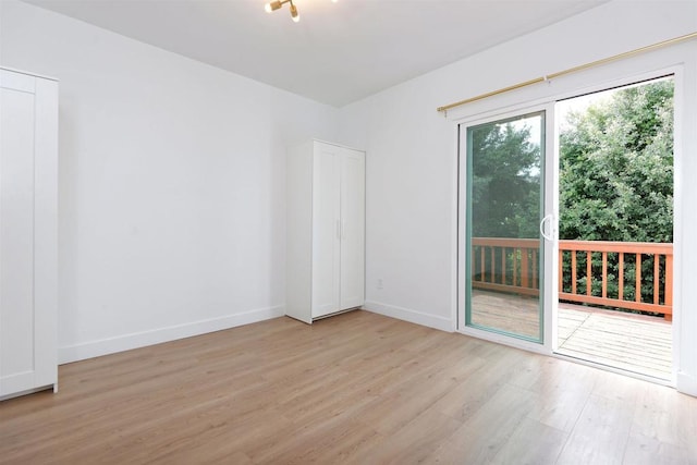 spare room with plenty of natural light, baseboards, and light wood-style flooring