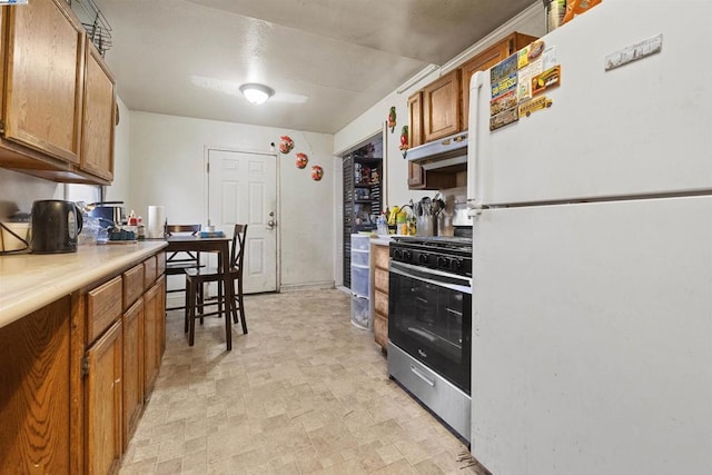 kitchen with stainless steel gas stove and white refrigerator