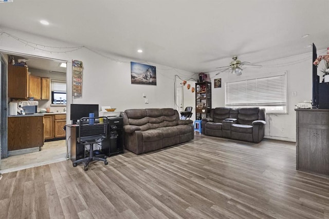 living room featuring light hardwood / wood-style flooring and ceiling fan