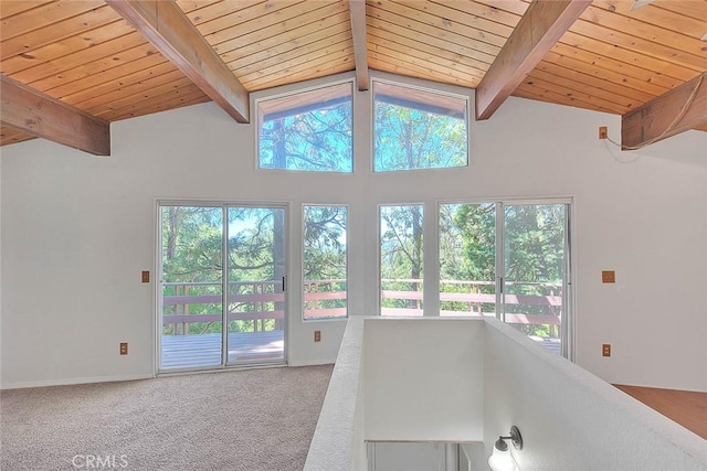 interior space with carpet, vaulted ceiling with beams, and wood ceiling