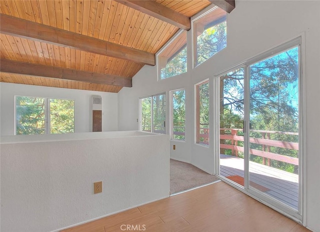 interior space with wood ceiling, a wealth of natural light, and vaulted ceiling with beams