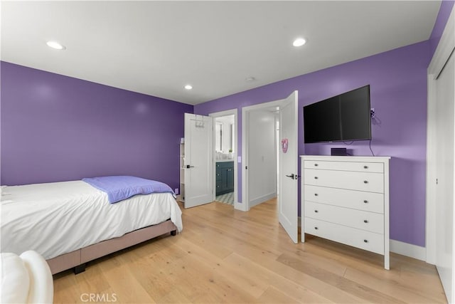 bedroom featuring ensuite bathroom and light hardwood / wood-style floors