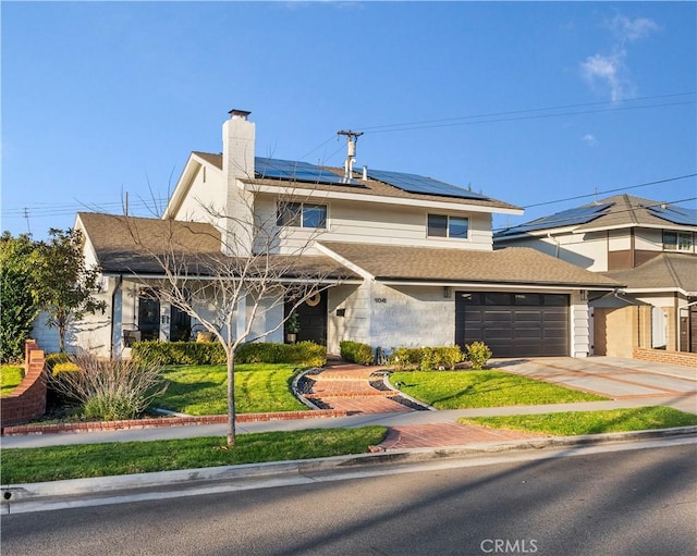 view of front of house with a garage, a front lawn, and solar panels