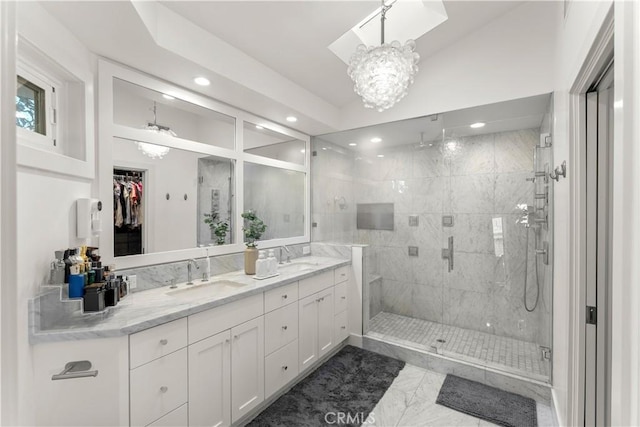 bathroom featuring an enclosed shower, vanity, and a notable chandelier