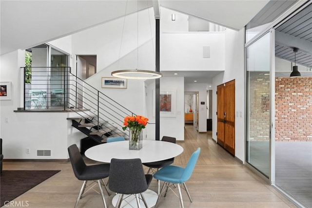 1900 Catalina St, Laguna Beach, CA 92651 - dining space featuring light wood-style floors, stairway, visible vents, and a towering ceiling