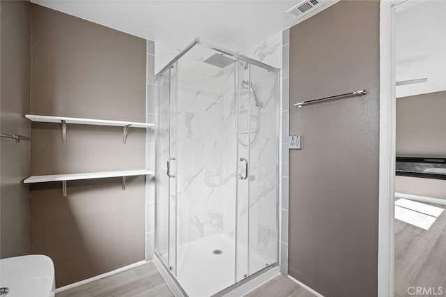 bathroom with wood-type flooring and a shower with door