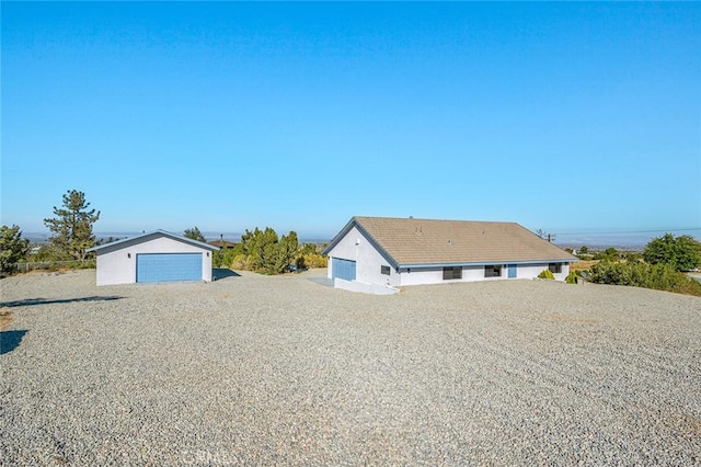 view of front of house featuring a garage and an outbuilding