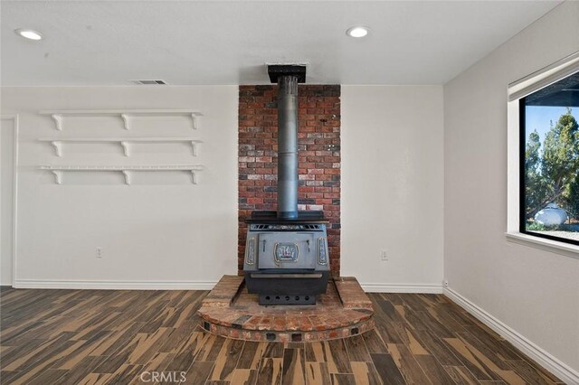 room details with hardwood / wood-style flooring and a wood stove