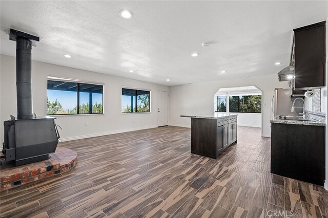 kitchen featuring light stone counters, dark hardwood / wood-style flooring, and a wood stove