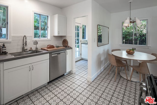 kitchen featuring tasteful backsplash, dishwasher, sink, white cabinets, and hanging light fixtures