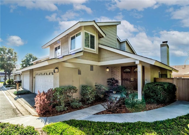 view of front of property with brick siding, fence, driveway, and stucco siding