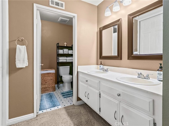 full bath featuring double vanity, visible vents, and a sink