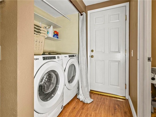 laundry room with laundry area, independent washer and dryer, and wood finished floors