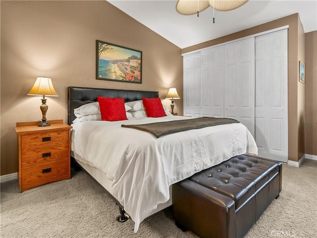 carpeted bedroom featuring a closet, a ceiling fan, baseboards, and vaulted ceiling