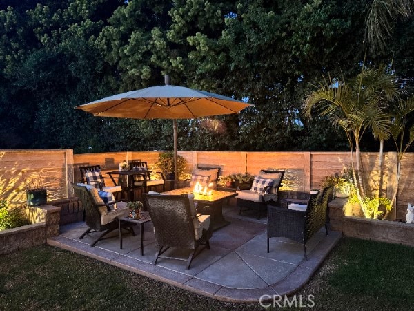 view of patio featuring an outdoor living space with a fire pit and fence