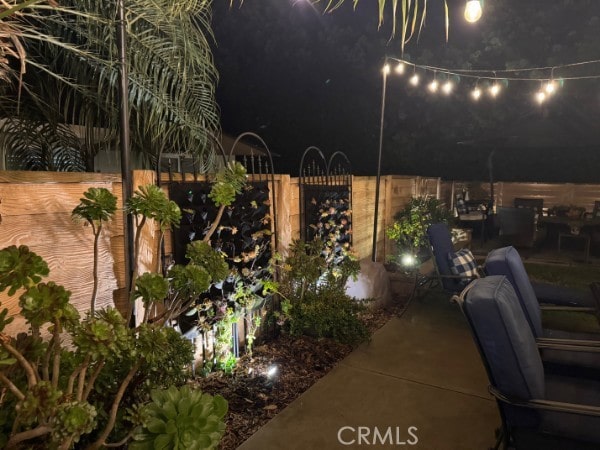 patio at twilight featuring fence