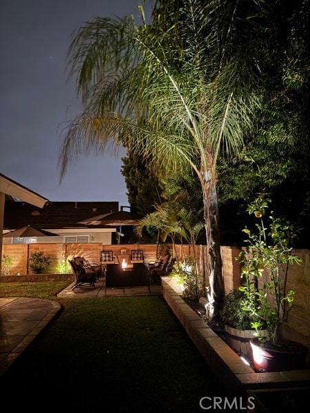 view of yard featuring a patio area, a fire pit, and a fenced backyard