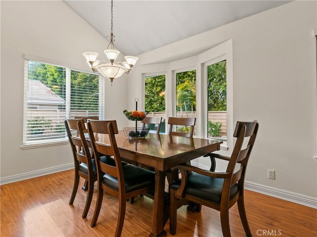 dining room featuring an inviting chandelier, baseboards, light wood finished floors, and vaulted ceiling