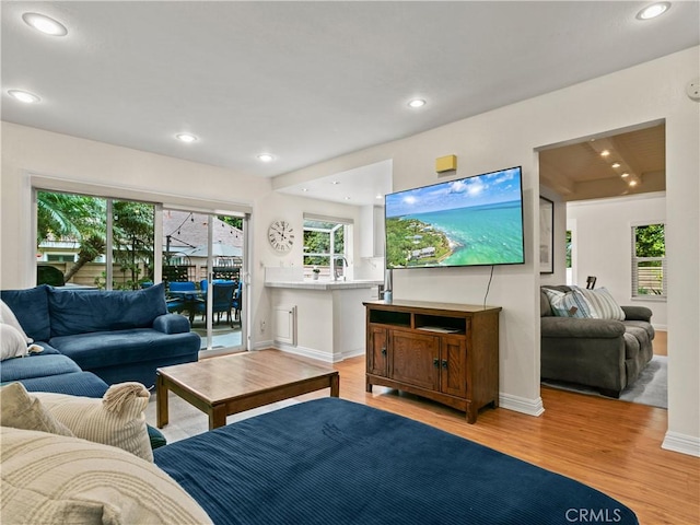 living room featuring recessed lighting, light wood-type flooring, and baseboards