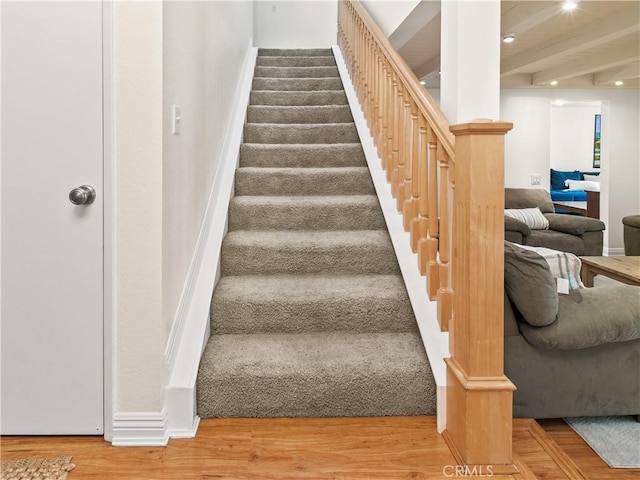 staircase featuring recessed lighting, beam ceiling, and wood finished floors