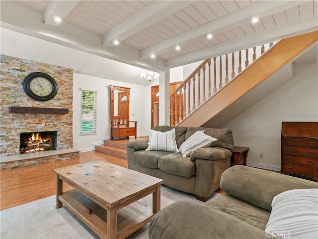 living area with stairway, wood finished floors, baseboards, an inviting chandelier, and beamed ceiling