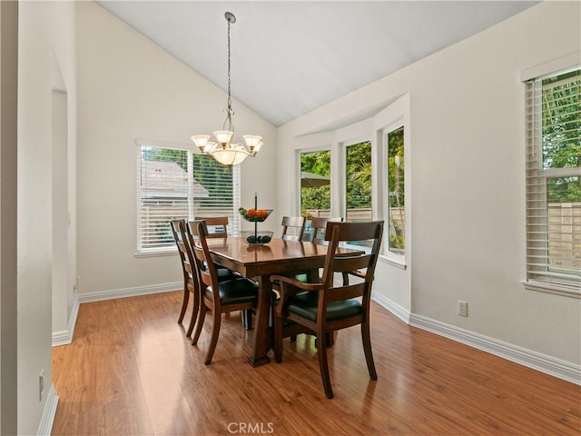 dining space featuring lofted ceiling, a notable chandelier, baseboards, and light wood-type flooring