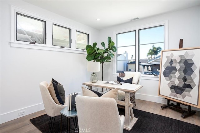 home office with hardwood / wood-style flooring and a healthy amount of sunlight