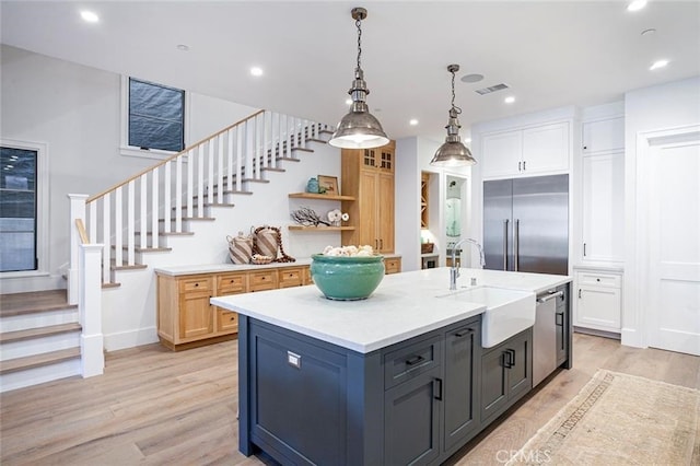 409 39th St, Newport Beach, CA 92663 - kitchen featuring appliances with stainless steel finishes, light countertops, light wood-style flooring, an island with sink, and pendant lighting