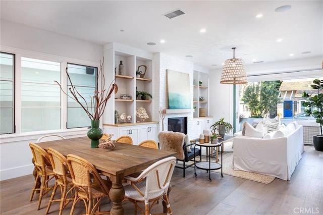 409 39th St, Newport Beach, CA 92663 - dining room featuring a fireplace, light wood-style floors, recessed lighting, built in shelves, and baseboards