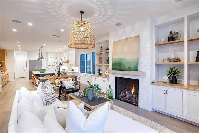409 39th St, Newport Beach, CA 92663 - living room with light wood-style floors, built in shelves, recessed lighting, and a fireplace