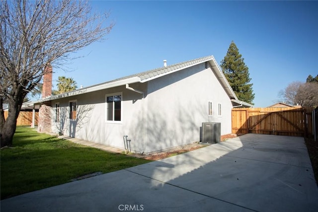 view of home's exterior featuring cooling unit and a lawn