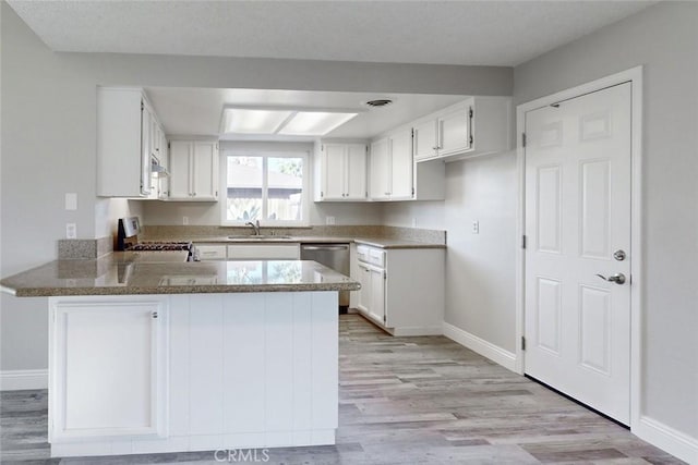 kitchen featuring white cabinetry, appliances with stainless steel finishes, and kitchen peninsula