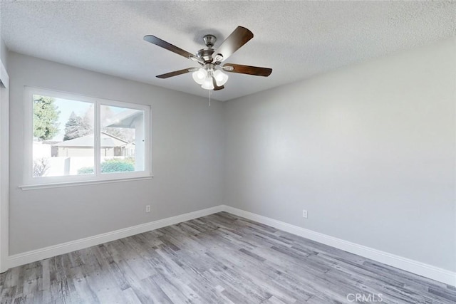 spare room with ceiling fan, a textured ceiling, and light wood-type flooring