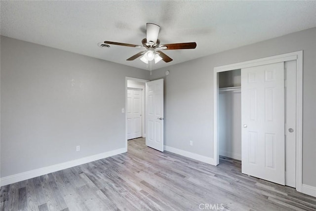 unfurnished bedroom with light hardwood / wood-style flooring, a closet, and ceiling fan