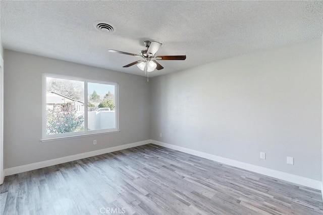 empty room featuring ceiling fan, a textured ceiling, and light wood-type flooring