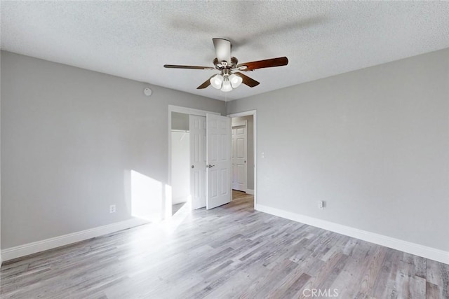 spare room with ceiling fan, a textured ceiling, and light hardwood / wood-style floors