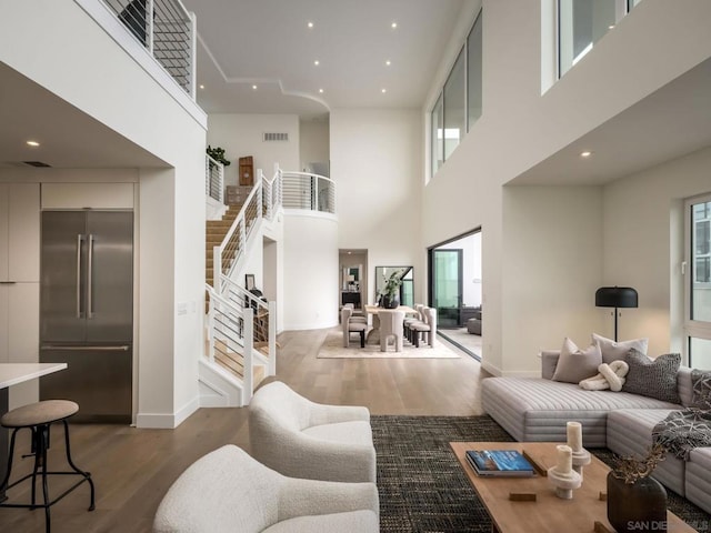 living room featuring wood-type flooring and a high ceiling