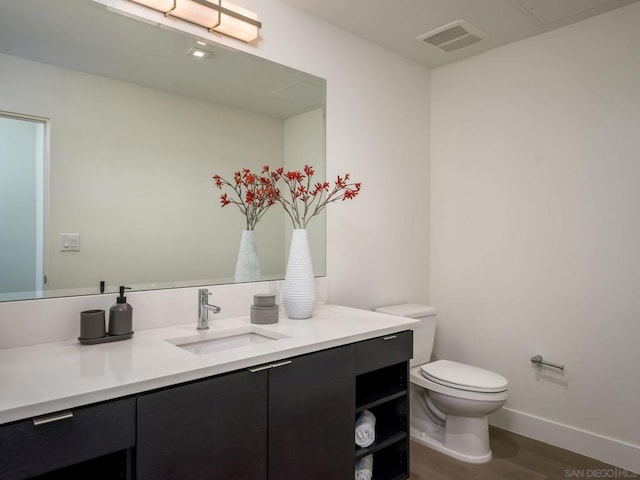 bathroom featuring vanity, hardwood / wood-style flooring, and toilet