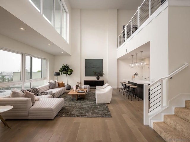 living room featuring hardwood / wood-style flooring and a towering ceiling