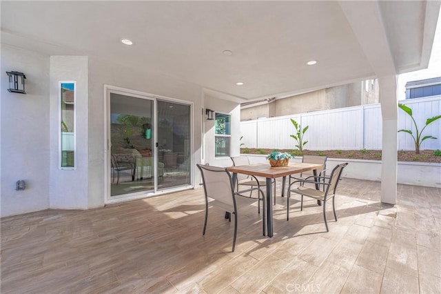 view of patio with outdoor dining space and fence