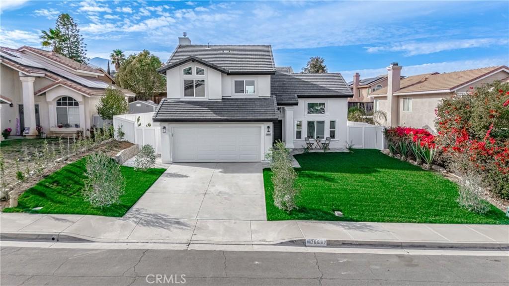 26687 Colt Dr, Corona, CA 92883 - traditional-style home featuring a tile roof, concrete driveway, fence, a garage, and a front lawn