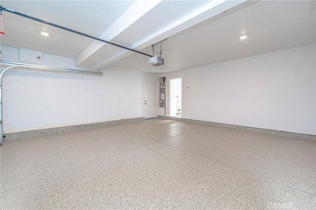 garage featuring a garage door opener, recessed lighting, and baseboards