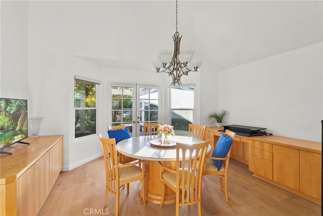 dining area featuring french doors, a chandelier, and light hardwood / wood-style flooring