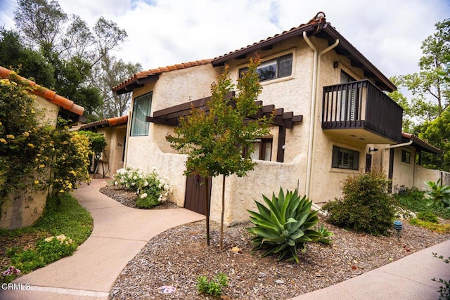 205 Pirie Rd Unit 64, Ojai, CA 93023 - view of side of home with a balcony, stucco siding, and a tiled roof
