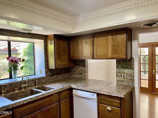 205 Pirie Rd Unit 64, Ojai, CA 93023 - kitchen with white dishwasher, decorative backsplash, crown molding, wood finished floors, and brown cabinetry
