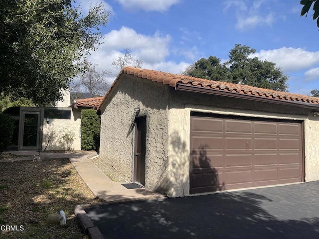 205 Pirie Rd Unit 64, Ojai, CA 93023 - view of property exterior with stucco siding, a garage, and a tiled roof
